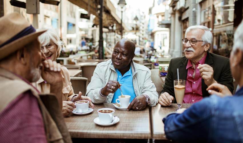 Group of senior travellers relaxing in a cafe after exploring the city