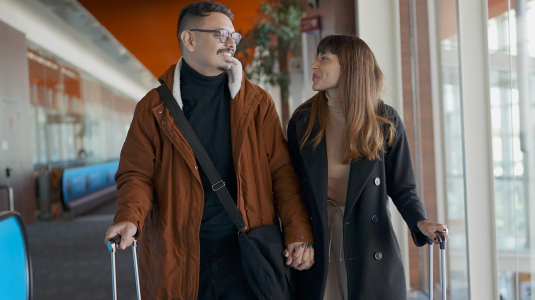 Couple at the airport holding their luggage