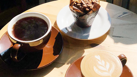 Image showing a cup of coffee and several desserts on a table.
