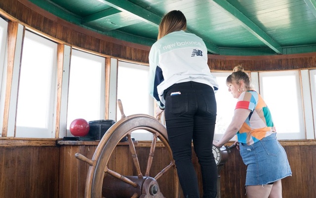 Image showing two children playing with a ships wheel inside a ship wheelhouse.